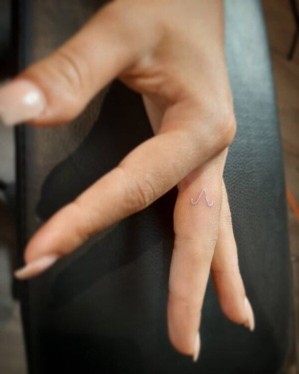 Minimalist Aries constellation tattoo on the finger
