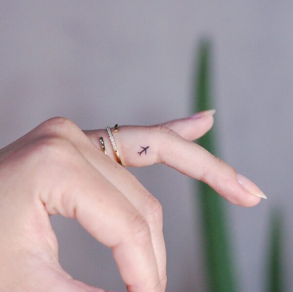 Tiny Airplane Finger Tattoo