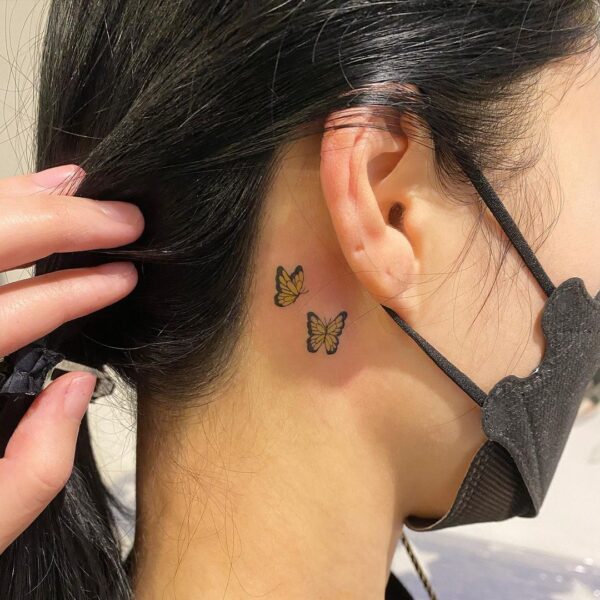 Fine line butterfly tattoo behind the ear