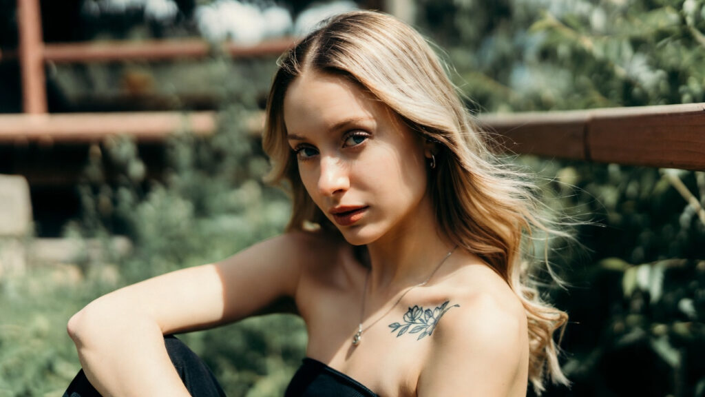 Small floral shoulder tattoo on a woman’s collarbone area