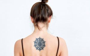 woman with circular tattoo design on back